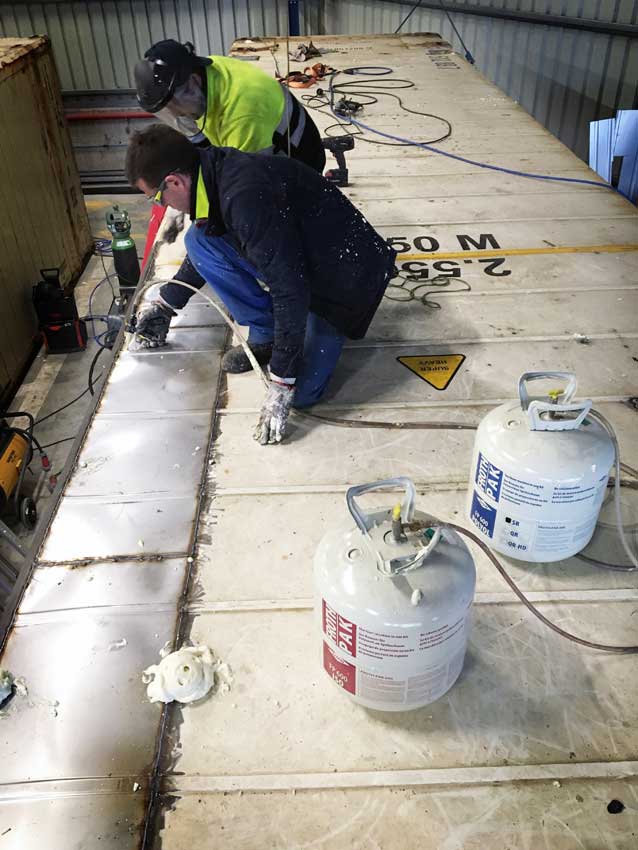 een foto van werknemers die 2 componenten-PUR aanbrengen in een container.