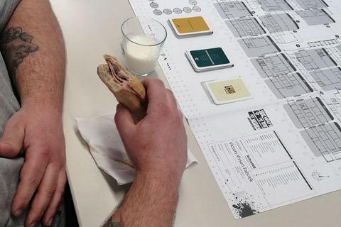 Foto van iemand die tijdens zijn lunch het Gevaarlijke Stoffen spel bekijkt.