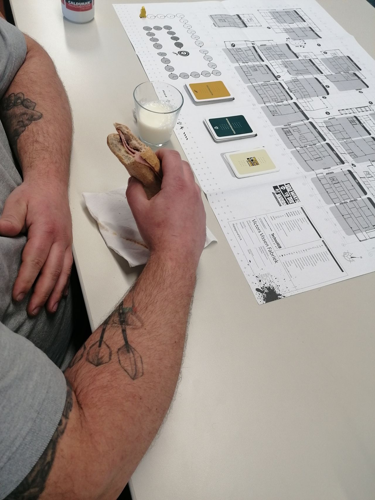 Foto van iemand die tijdens zijn lunch het Gevaarlijke Stoffen spel bekijkt.